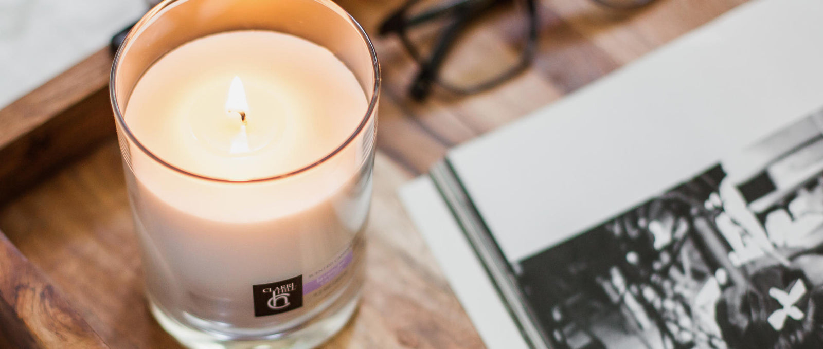 A photo of a clear glass candle with a relaxing lavender vanilla scent, handcrafted by Clarri Hill with premium natural ingredients for the ultimate in home fragrance